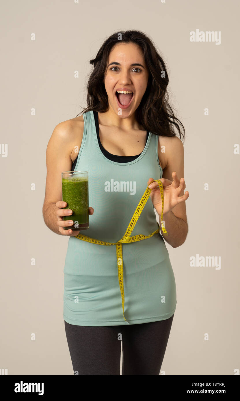 Fitness woman smiling happy with diet plan to loose weight; exercise and green vegetable smoothie healthy drink. In Beauty body care, Health Fitness D Stock Photo
