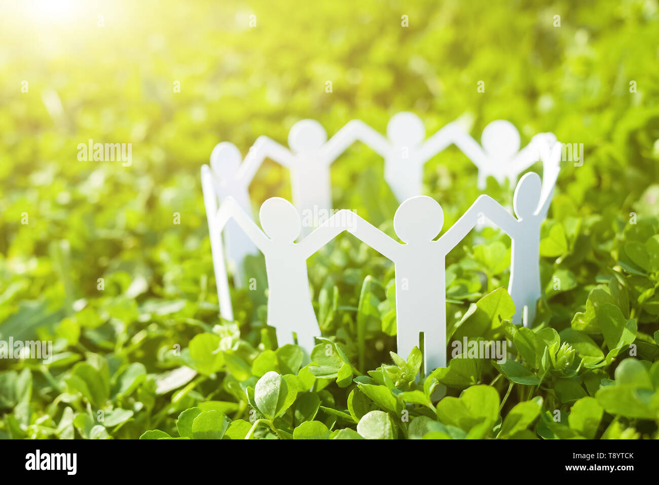 Group of paper people holding hands together. Concept of social help in group. Team concept Stock Photo