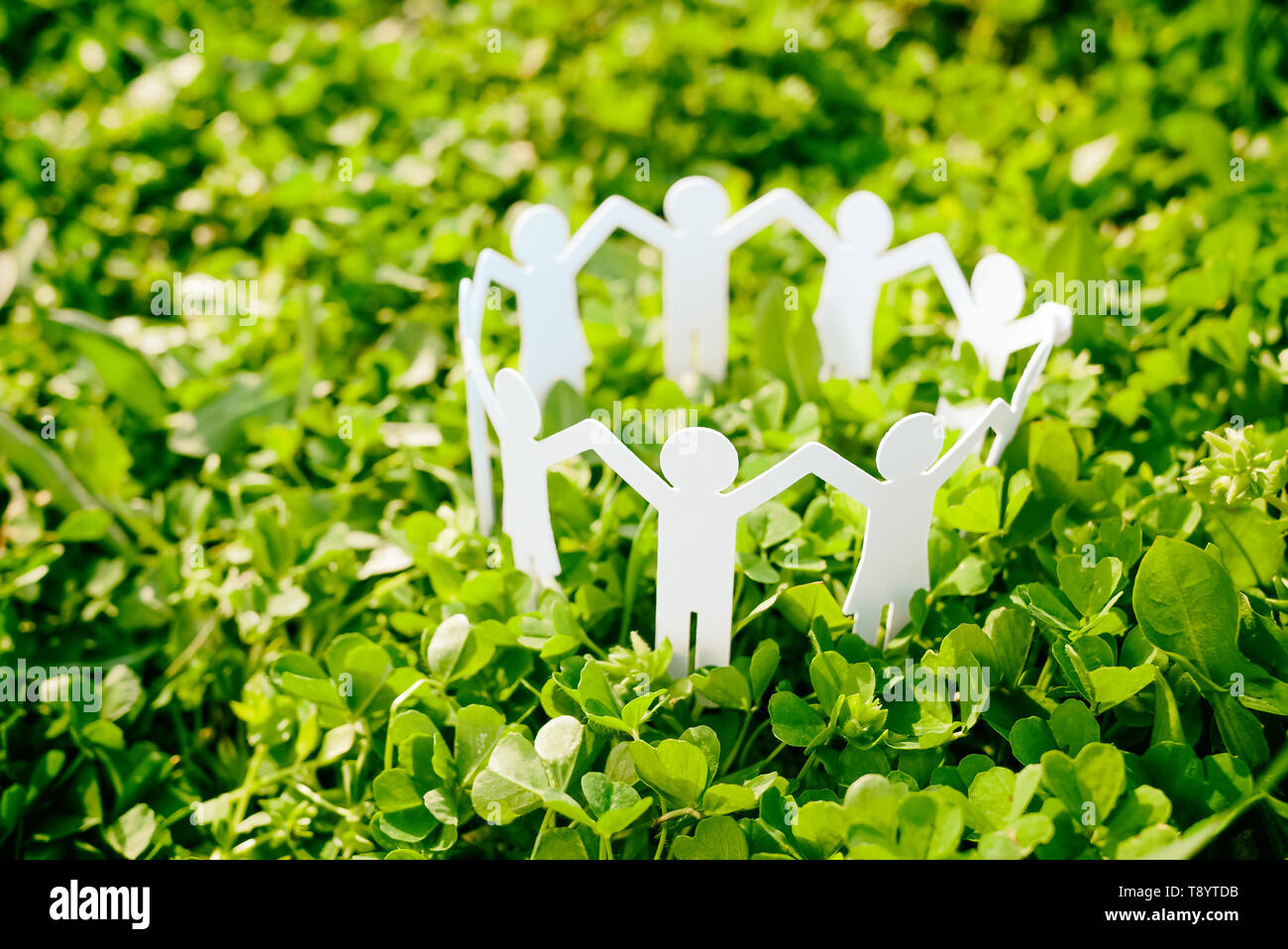 Group of paper people holding hands together. Concept of social help in group. Team concept Stock Photo