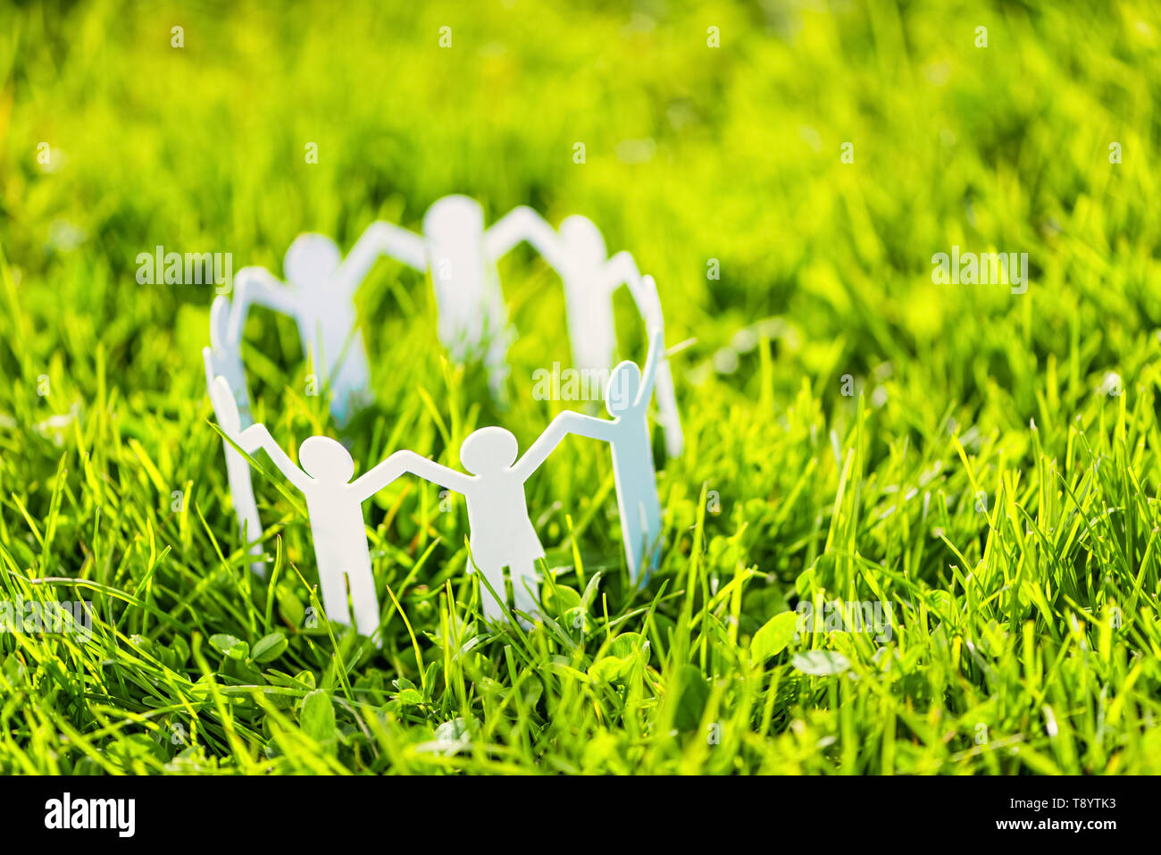 Group of paper people holding hands together. Concept of social help in group. Team concept Stock Photo