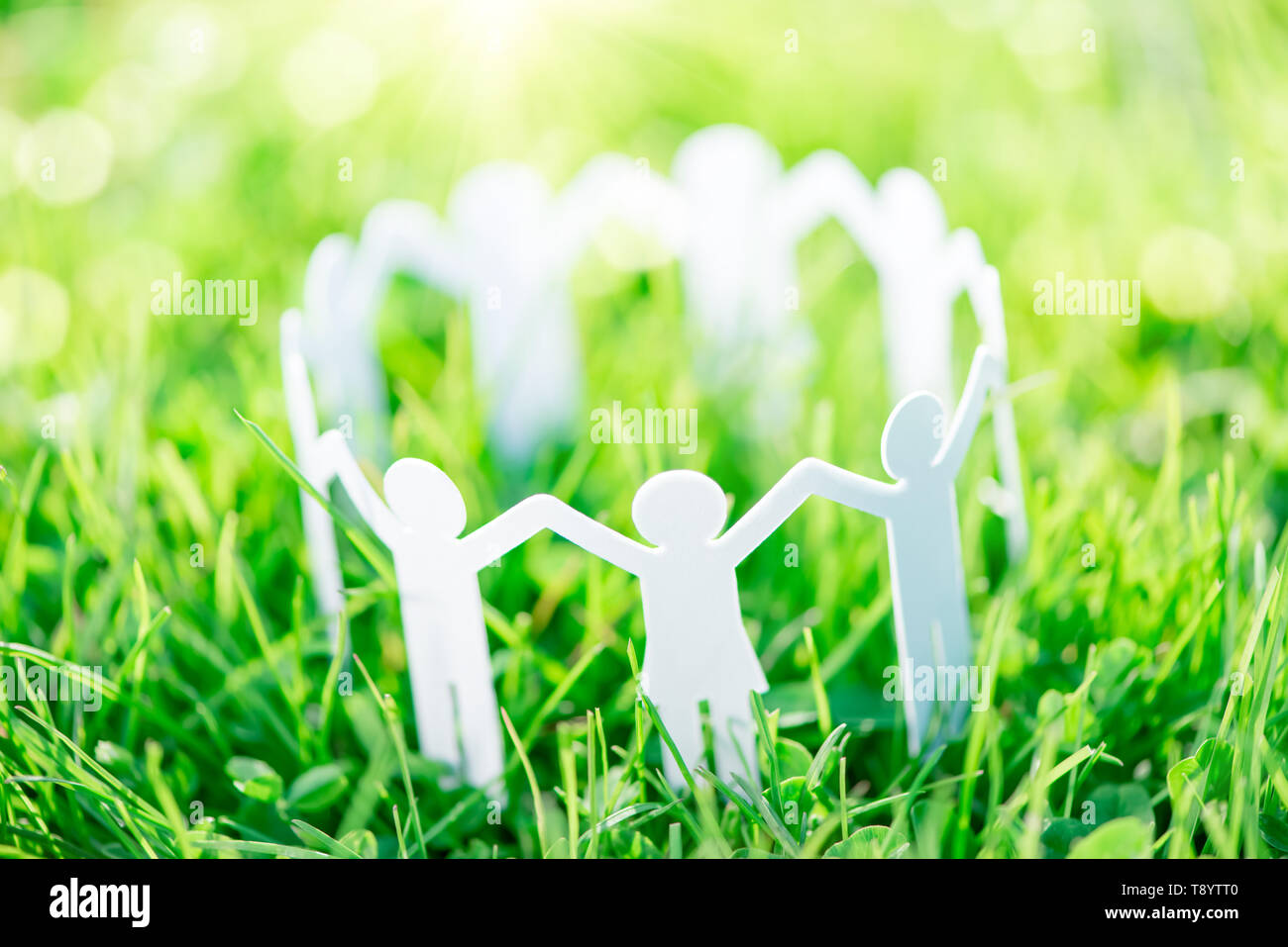 Group of paper people holding hands together. Concept of social help in group. Team concept Stock Photo