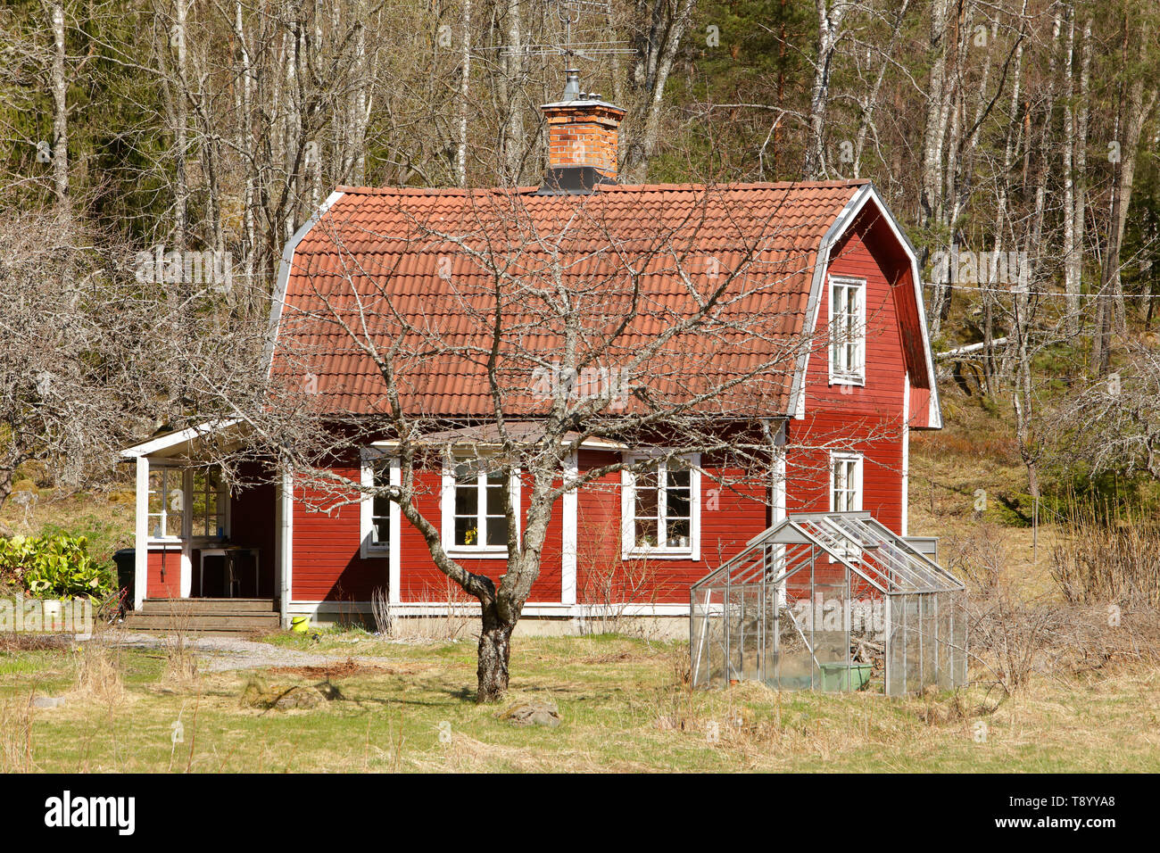 Typical Swedish countryside old wooden single-family red dwelling with a mansard roof. Stock Photo
