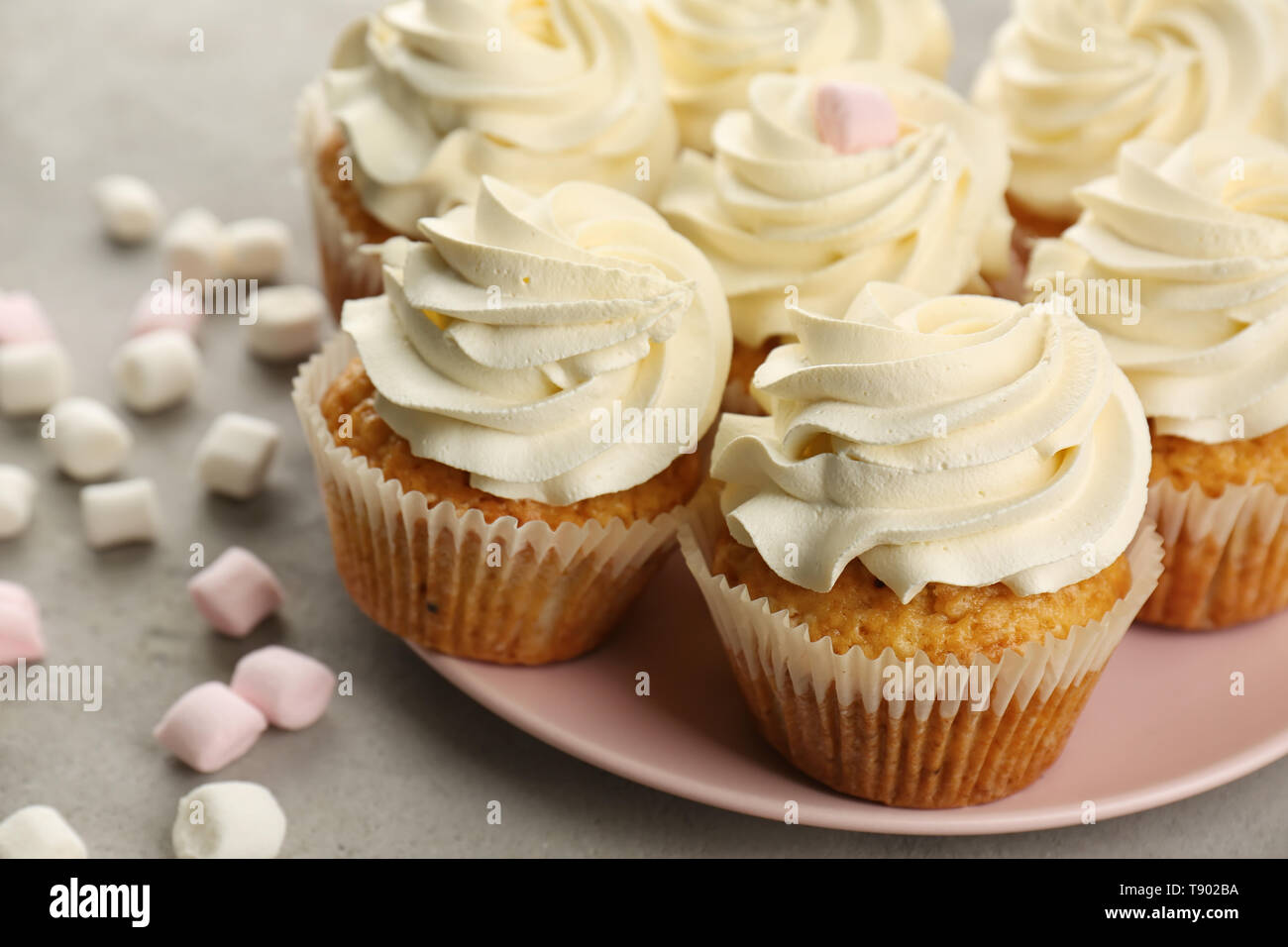 Plate with sweet cupcakes and marshmallows on grey table, closeup Stock Photo