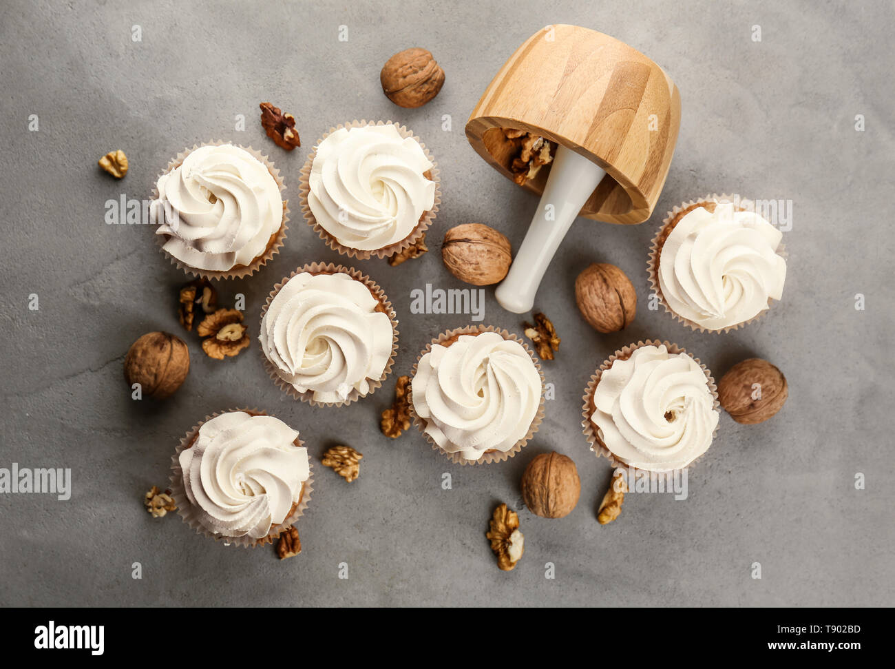 Delicious cupcakes with walnuts on grey table Stock Photo
