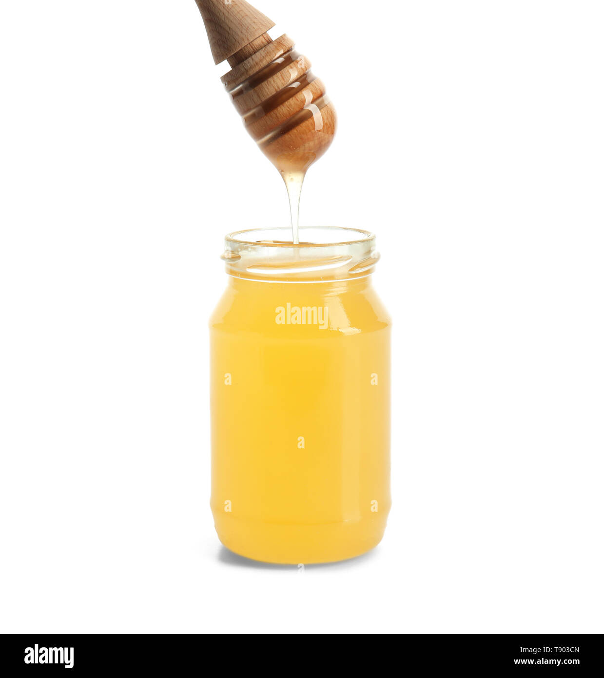 Honey dripping from dipper into jar on white background Stock Photo - Alamy