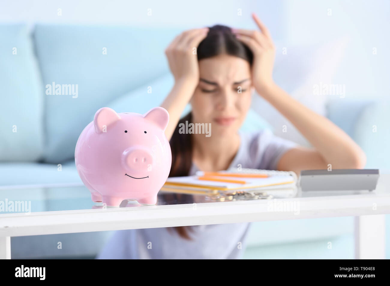 Piggy bank on table of young upset woman Stock Photo - Alamy