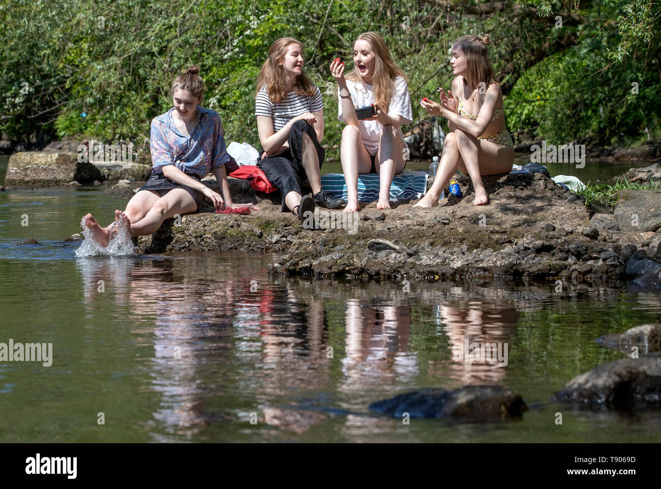 Glasgow University students (left to right) Mirren Buchanan, Lara Adams, Paula Starrs and Mia Holdsworth enjoy the sunshine alongside the River Kelvin in Glasgow as the hot weather continues. Stock Photo