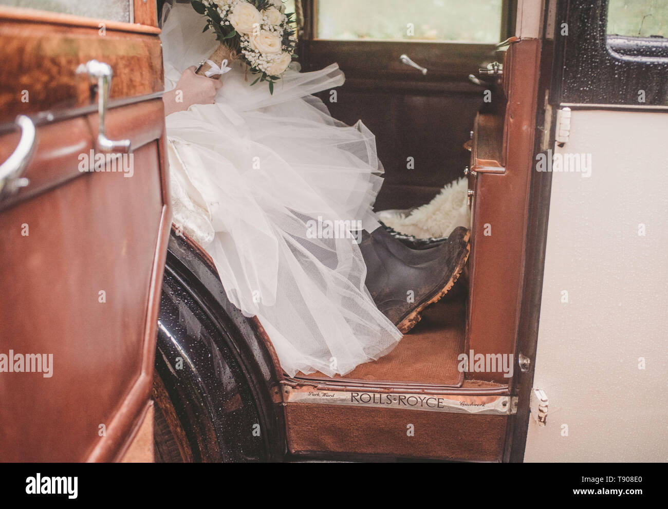 Bride in car with wellingtons Stock Photo