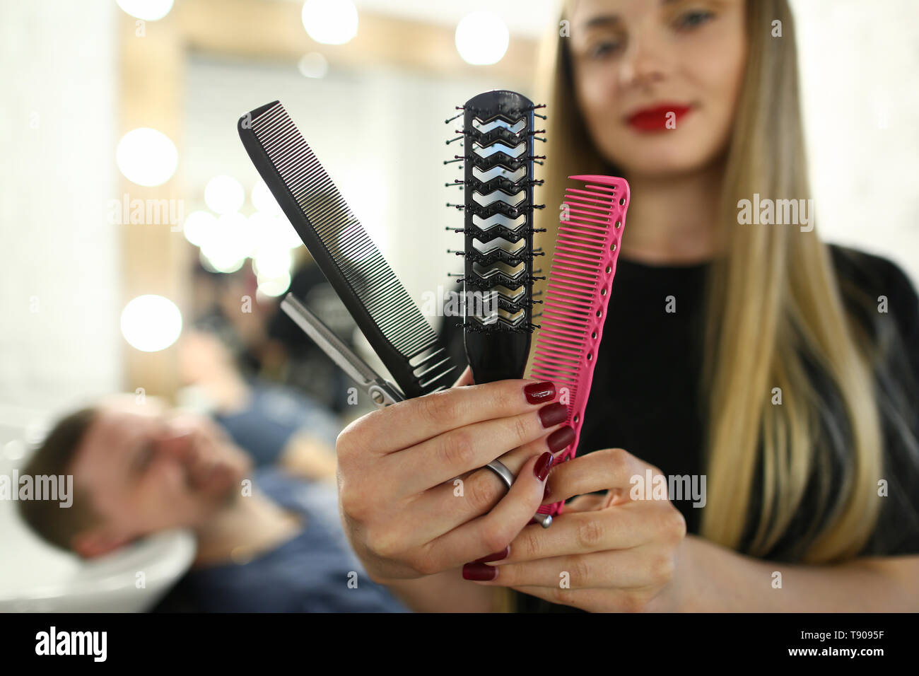 Beautiful Hairdresser Showing Comb and Scissors Stock Photo