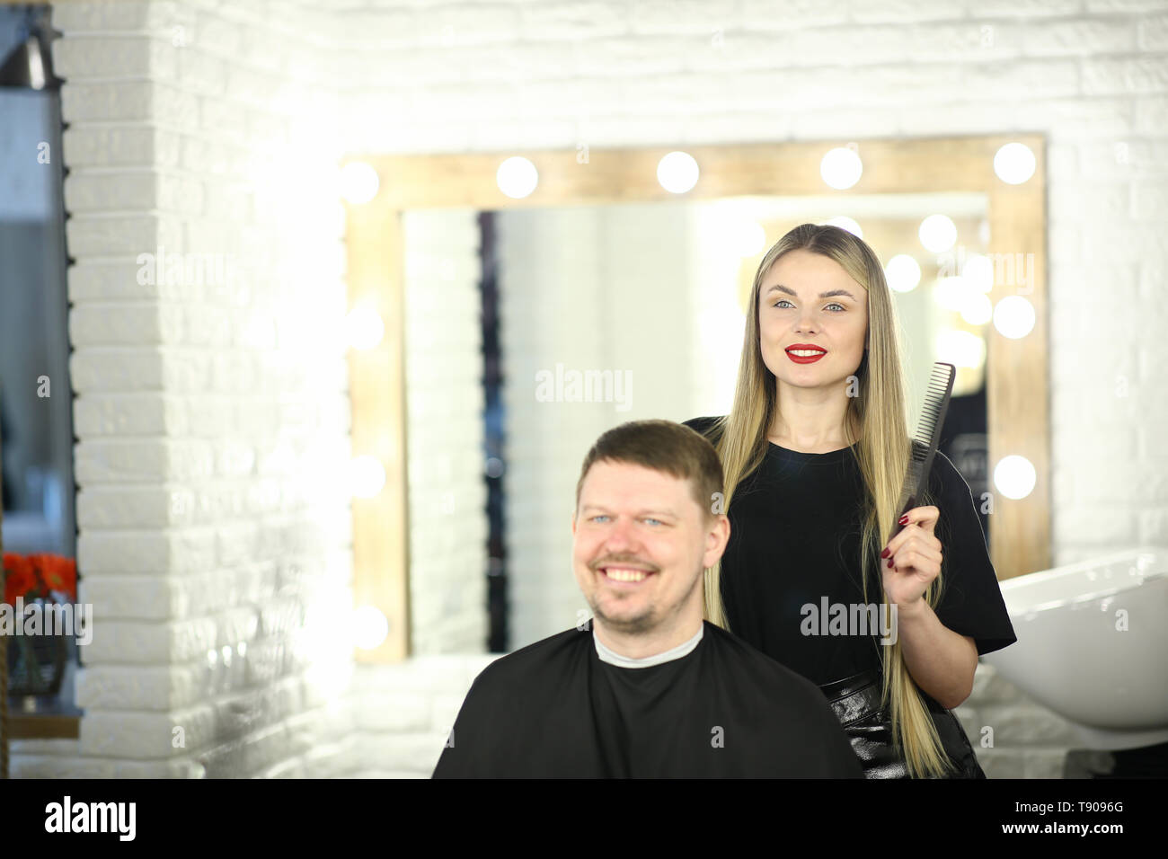 Girl Hairstylist and Man Customer in Beauty Studio Stock Photo