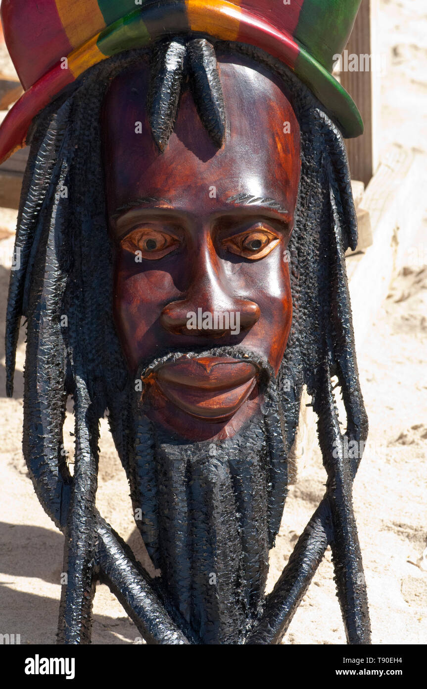 Wooden mask of a man with dreadlocks for sale at the beach market Stock Photo