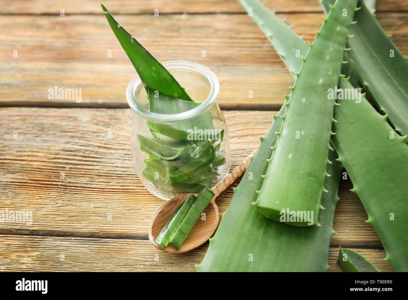 Jar And Spoon With Cut Aloe Vera Leaves On Wooden Table Stock