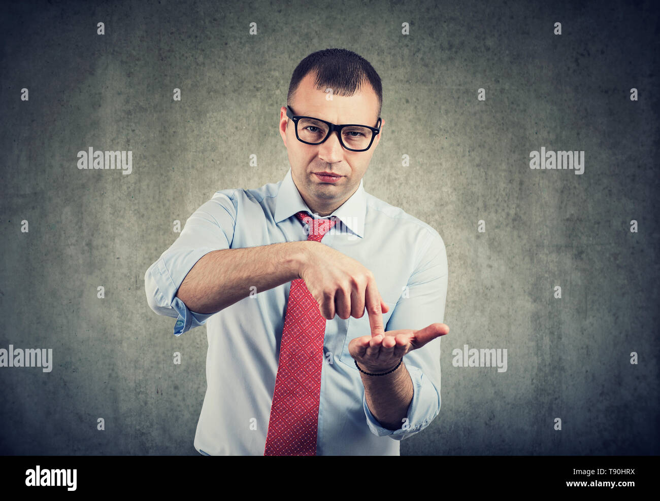 Serious business man in glasses asking for more money to pay back debt Stock Photo