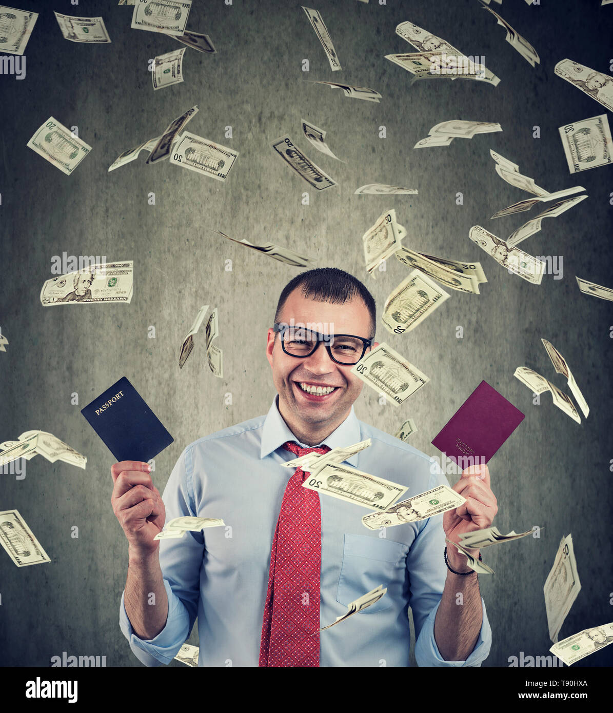 Citizenship for investment concept. Happy businessman with two passports under money rain Stock Photo