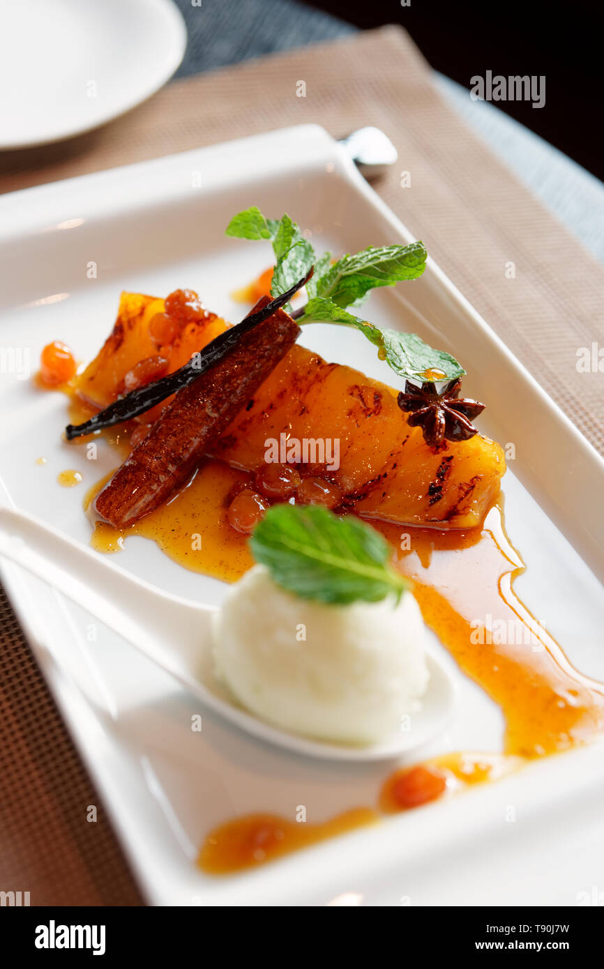 Grilled pineapple cooked in syrup, dessert on restaurant table Stock
