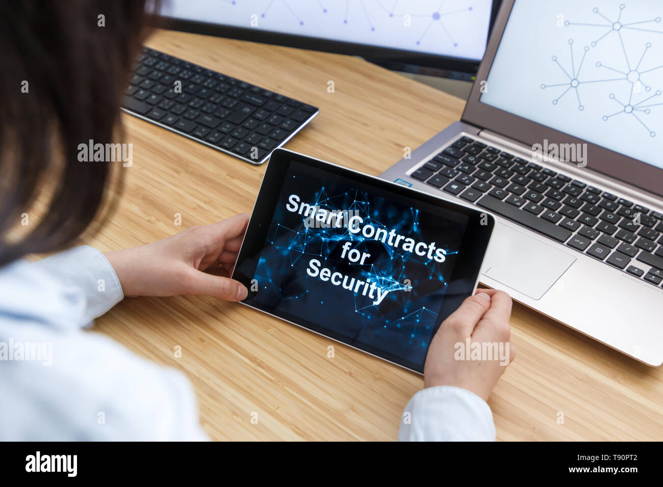 Business Female Using Smart Contracts For Security. Illustration of Ethereum Blockchain on the Screen of Tablet, PC and Laptop. Stock Photo