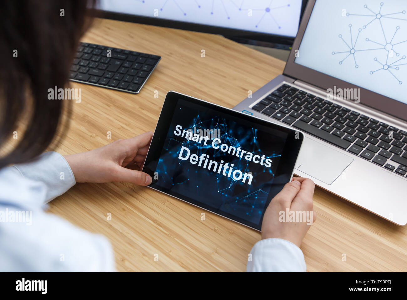 Business Female Using Smart Contracts For Definition. Illustration of Ethereum Blockchain on the Screen of Tablet, PC and Laptop. Stock Photo