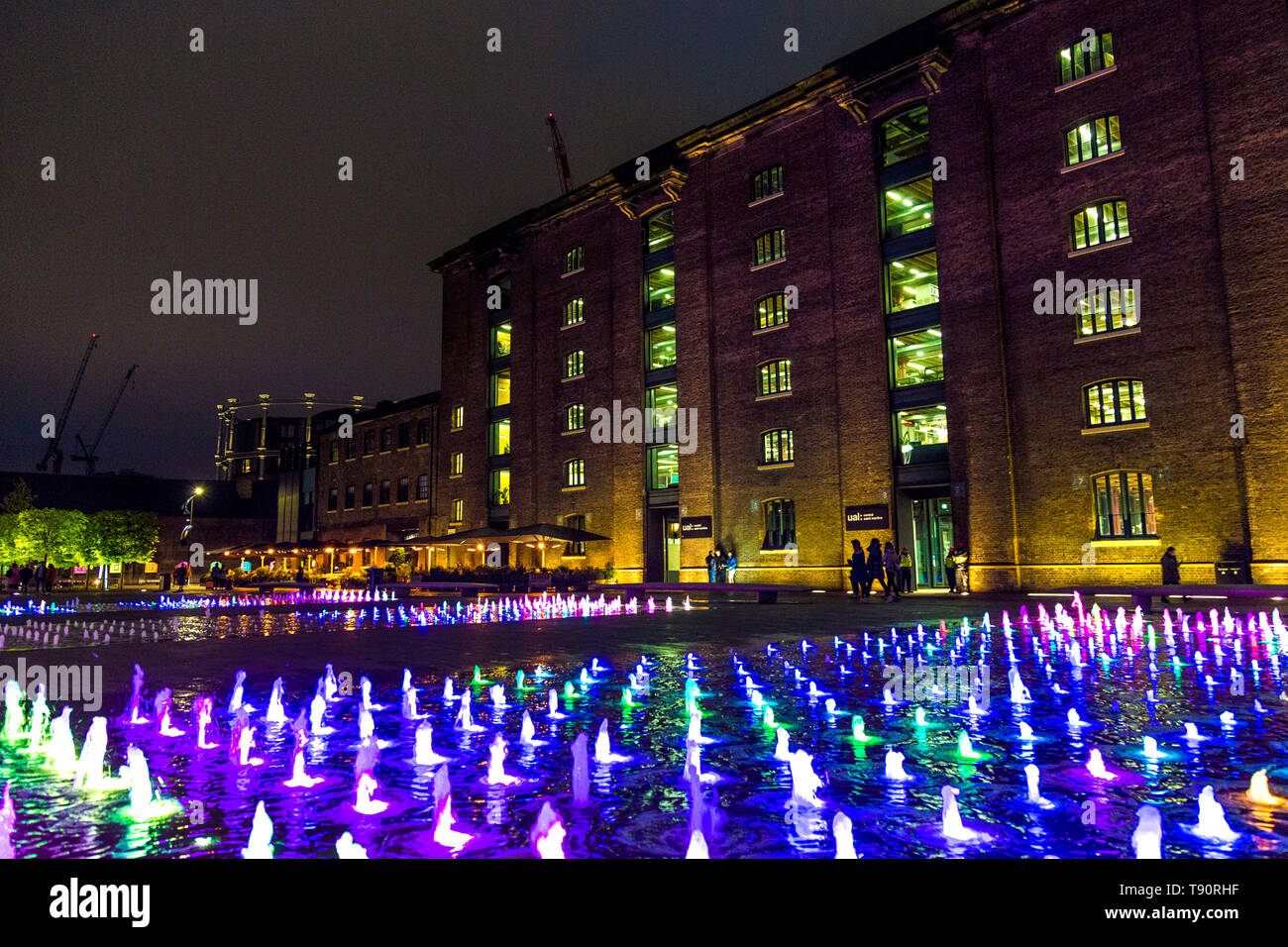 Colourful fountain at night in front of the Central St Martins building in Granary Square , Kings Cross, London Stock Photo