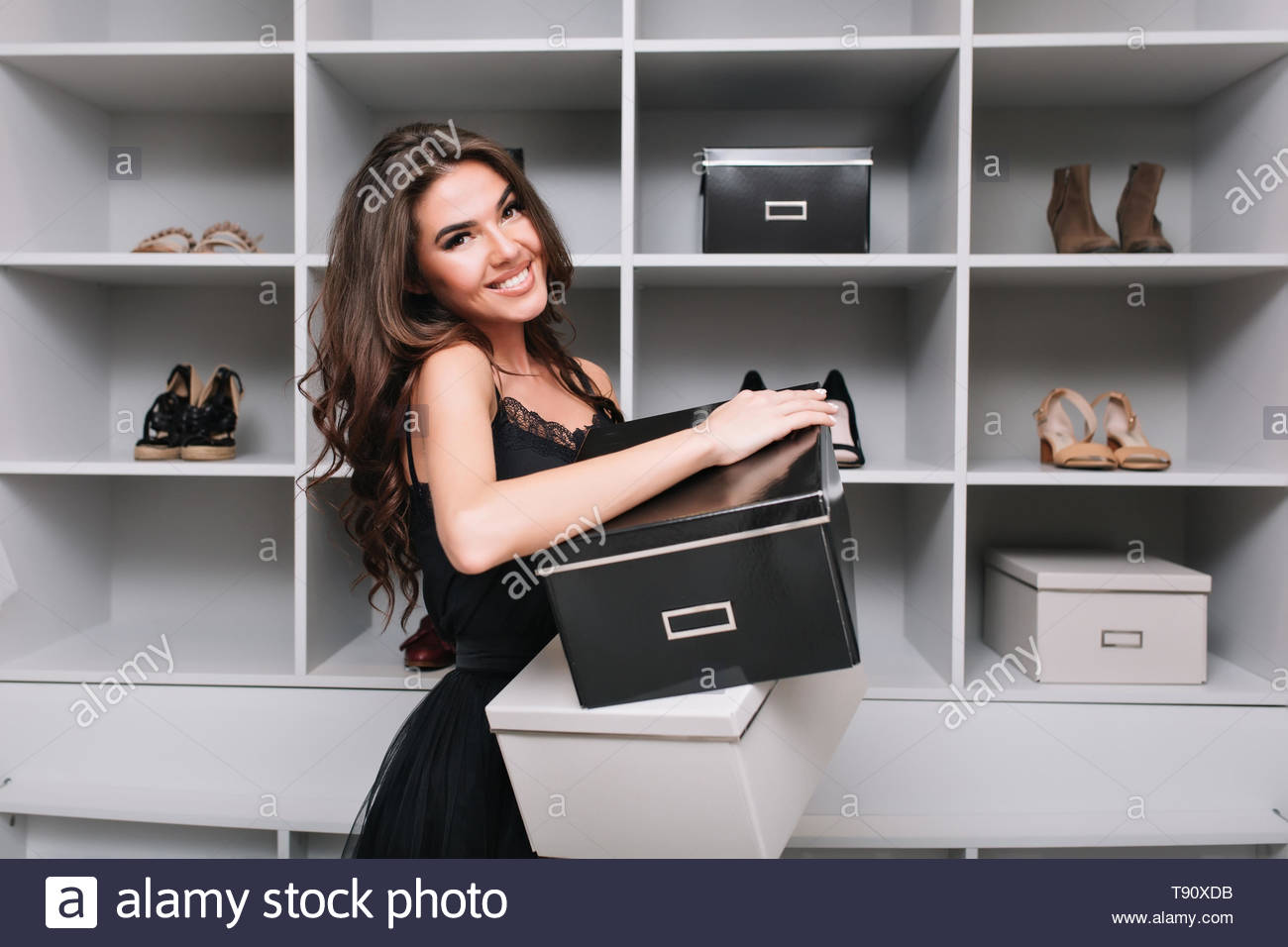 Cheerful Young Woman Holding Boxes Of Shoes In Hands