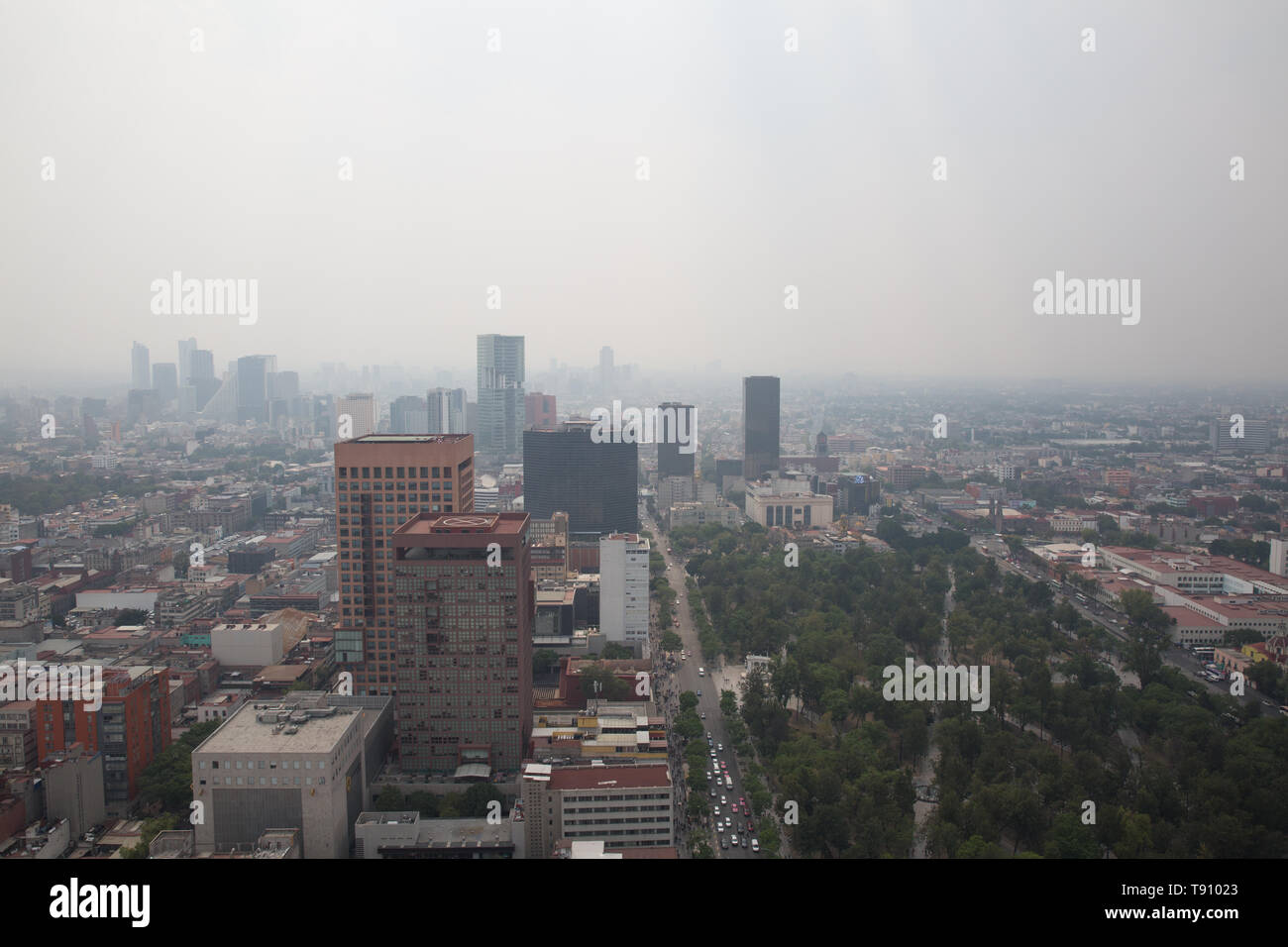 A haze of hazardous smoke covers Mexico City, Mexico on May 15, 2019. A series of wildfires on the city and its outskirts have combined with stagnant weather conditions to cloak the metropolitan area of more than 22 million people in a gray cloud of air pollution. The Environmental Commission of the Megalopolis issued an Extraordinary Environmental Contingency for the Mexico City metropolitan area after measuring extremely high levels of PM2.5 — fine particulate matter, on Tuesday. Mexico City's government has advised people to stay indoors, cancelled schools and restricted traffic due to air Stock Photo