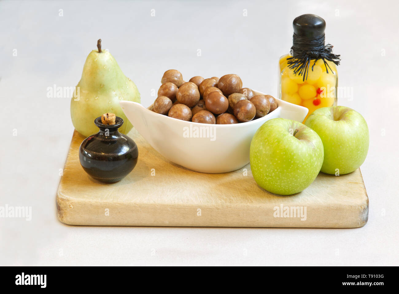 Fruit, nuts and containers on a board. Still Life Stock Photo