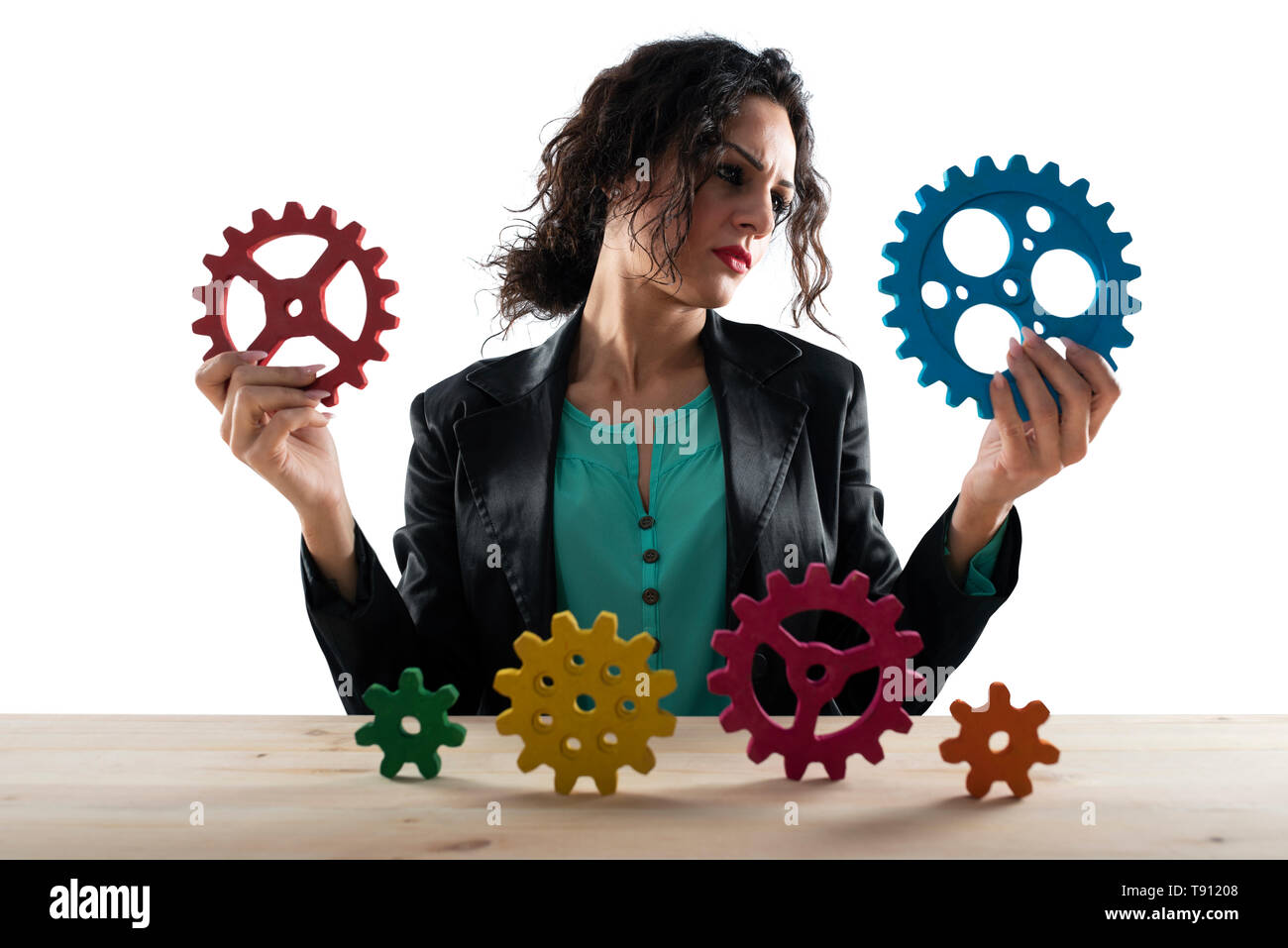 Businesswoman tries to work with gears. Concept of teamwork and partnership. Isolated on white background Stock Photo