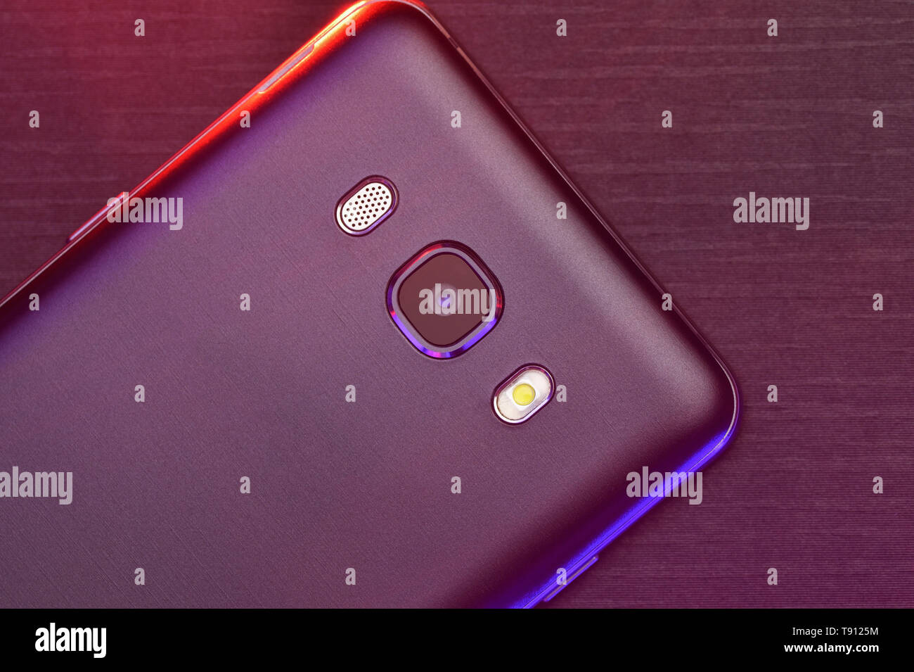 Closeup of a cell phone in black lies the camera to the top on a black