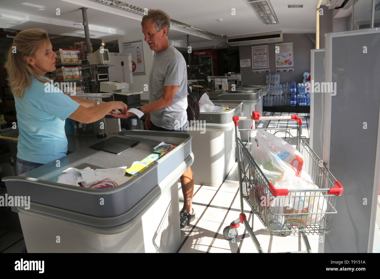 Vouliagmeni Attica Greece man buying groceries at Greek supermarket Stock Photo