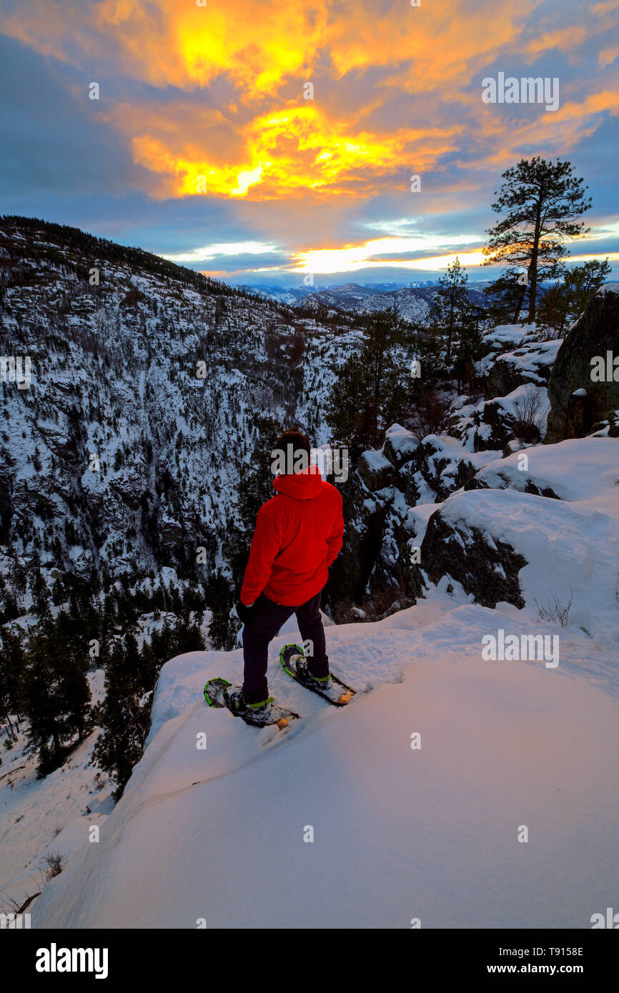 Snowshoer watching the sunset over the Ellis Creek Canyon in Penticton, British Columbia, Canada Stock Photo