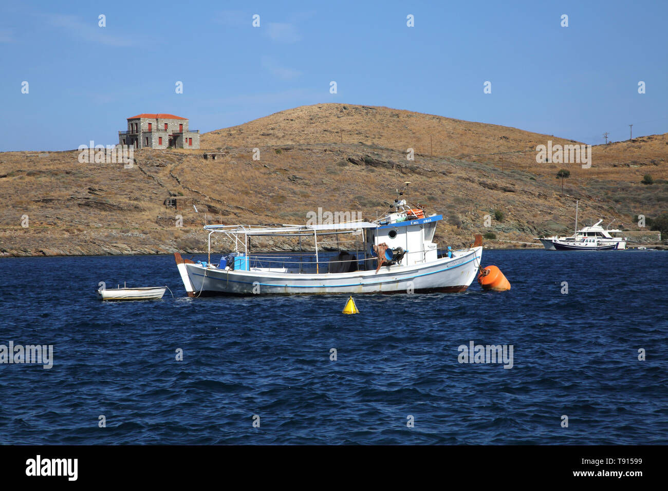 Vourkari Kea Island Greece isolated house on barren promontory and Fishing Boats Stock Photo