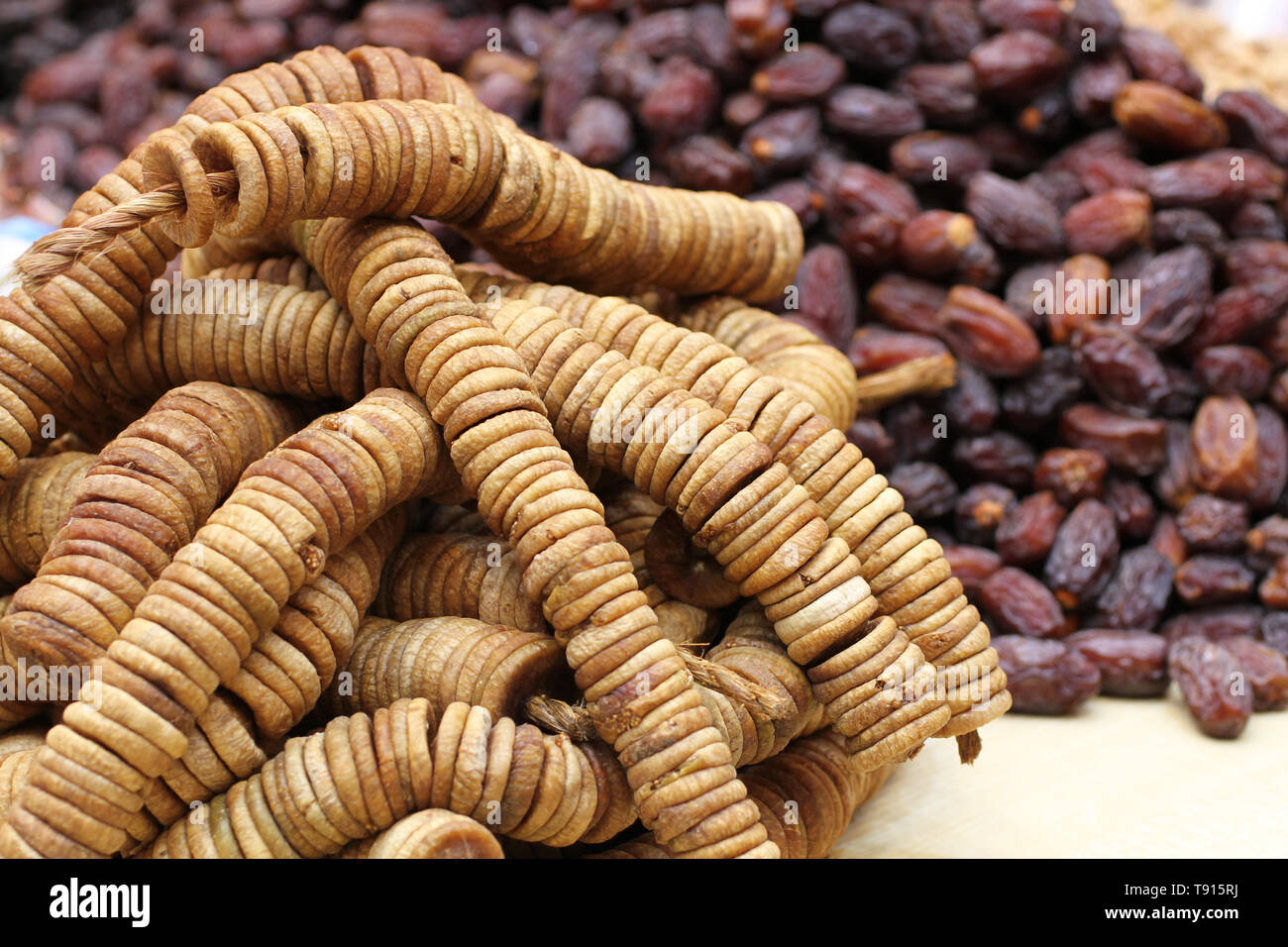 Big dried dates and dried figs strung on twine, lying on a large