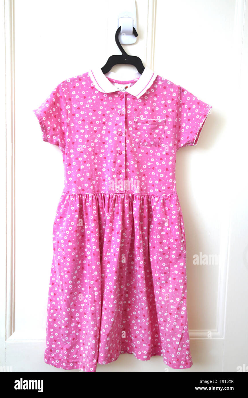 A Child's Pink Floral Cotton Button Up Shirt Dress with Collar Stock Photo