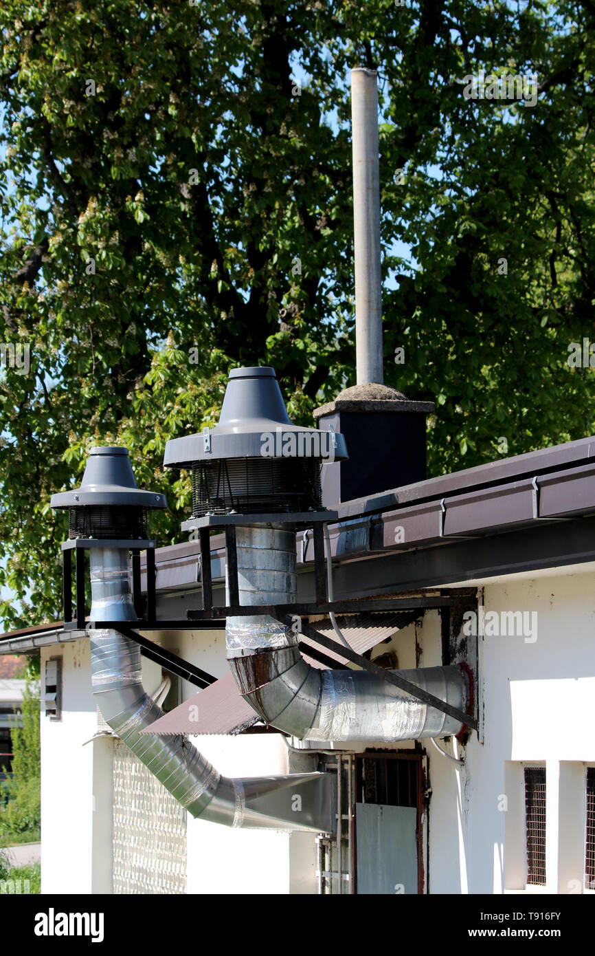 Restaurant kitchen industrial chimneys with large filters and metal protection at top mounted on