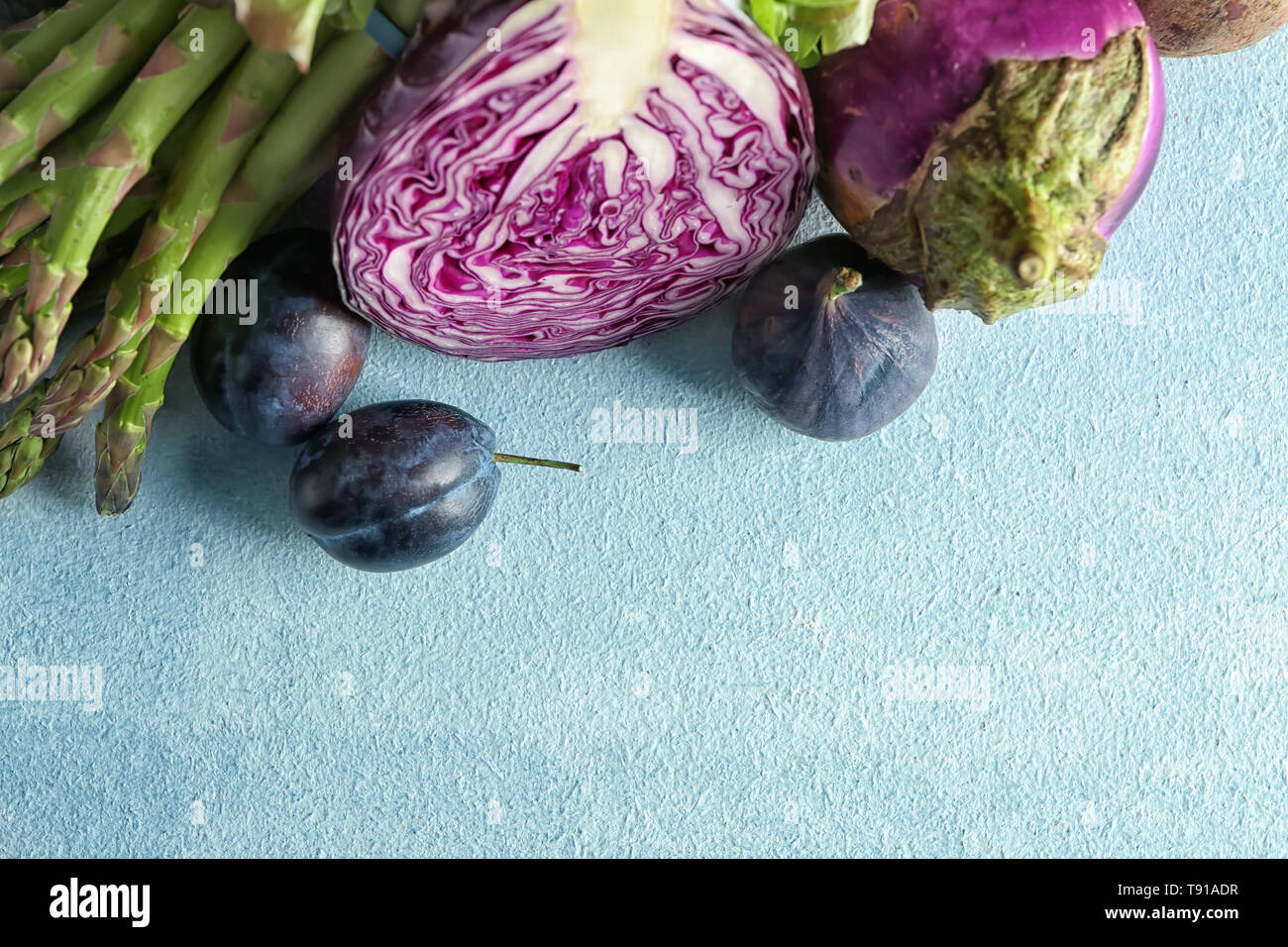 Various fresh vegetables with plums on color table Stock Photo - Alamy