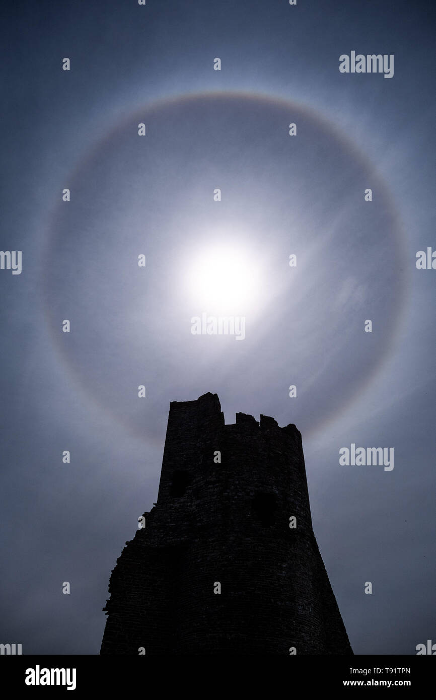Aberystwyth Wales UK, Thursday 16 May 2019  UK Weather: A perfect circular sun halo , formed as the rays of the sun shine through ice crystals in the upper atmosphere, seen in the sky above  the ruins of Aberystwyth castle. The halos, always at 22º from the sun,  often  indicate that rain will fall within the next 24 hours, since the cirrostratus clouds that cause them can signify an approaching frontal system. The  weather is set to change overnight from the fine warm conditions to cooler and wetter days, more typical of mid May.  photo credit Keith Morris / Alamy Live News Stock Photo