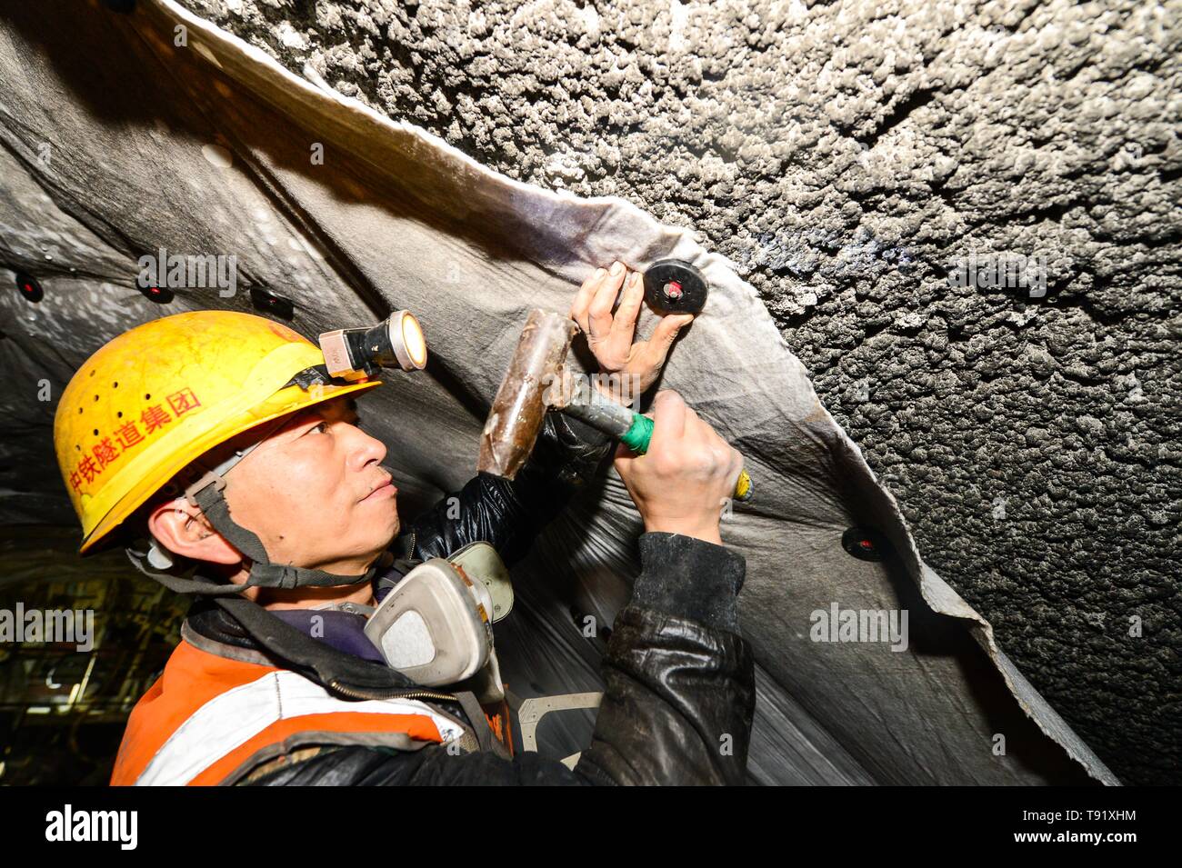 (190516) -- RUOQIANG, May 16, 2019 (Xinhua) -- Construction worker Zhong Yingxue operates waterproof task in the tunnel though Altun Mountains in Ruoqiang County, northwest China's Xinjiang Uygur Autonomous Region, May 15, 2019. The 13.195-kilometer-long tunnel through Altun Mountains is the longest tunnel of the Golmud-Korla railway line. The railway line, connecting Golmud in Qinghai and Korla in Xinjiang, is the third rail artery linking Xinjiang with neighboring provinces. The line will cut the traffic time between Golmud and Korla from 26 hours to 12 hours. (Xinhua/Ding Lei) Stock Photo