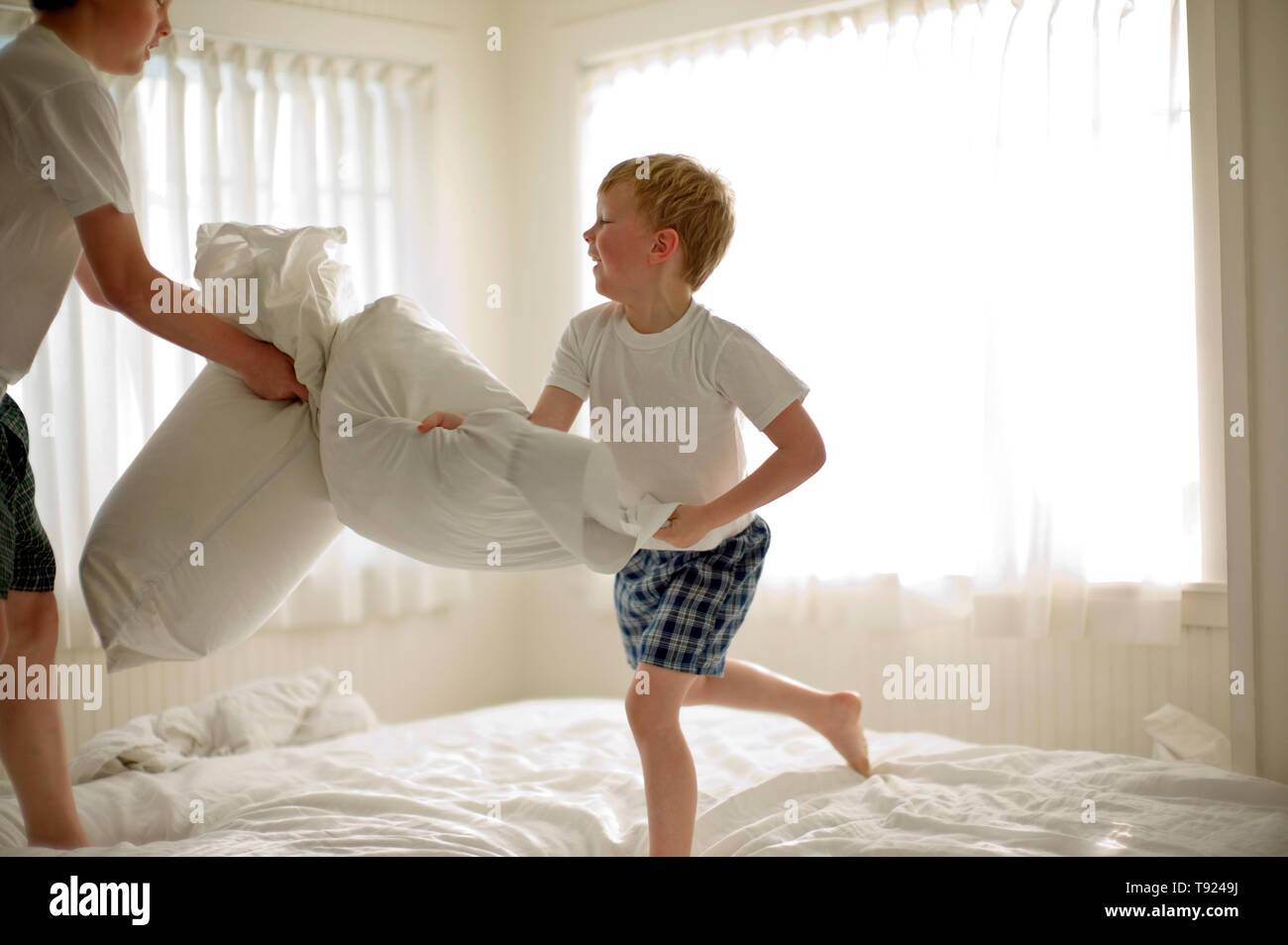 Two brothers pillow fighting on the bed Stock Photo Alamy