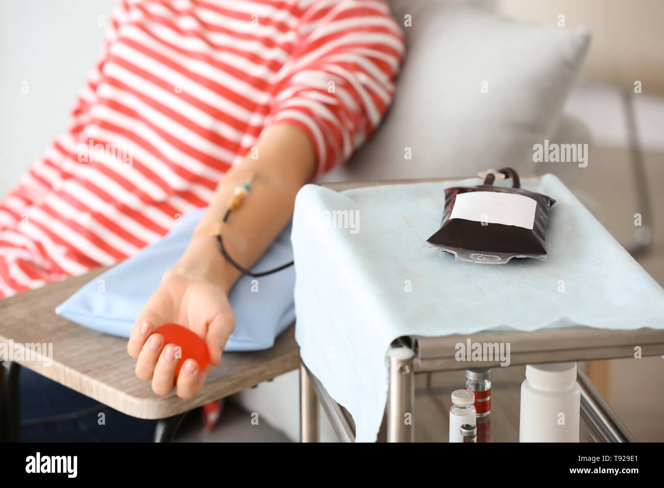 Woman with grip ball donating blood in hospital Stock Photo