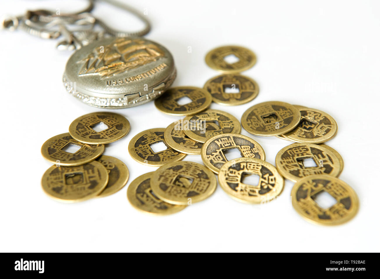 Pocket watch and ancient Chinese coins Stock Photo
