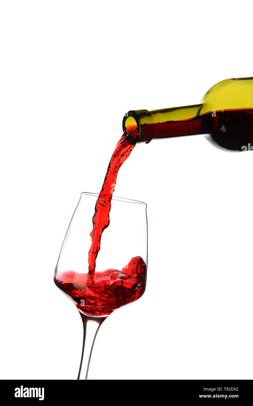 Tasty wine pouring from bottle into glass on white background Stock
