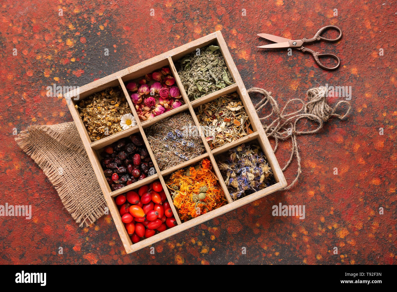 Wooden box with various dried flowers, herbs and rose hips on color ...