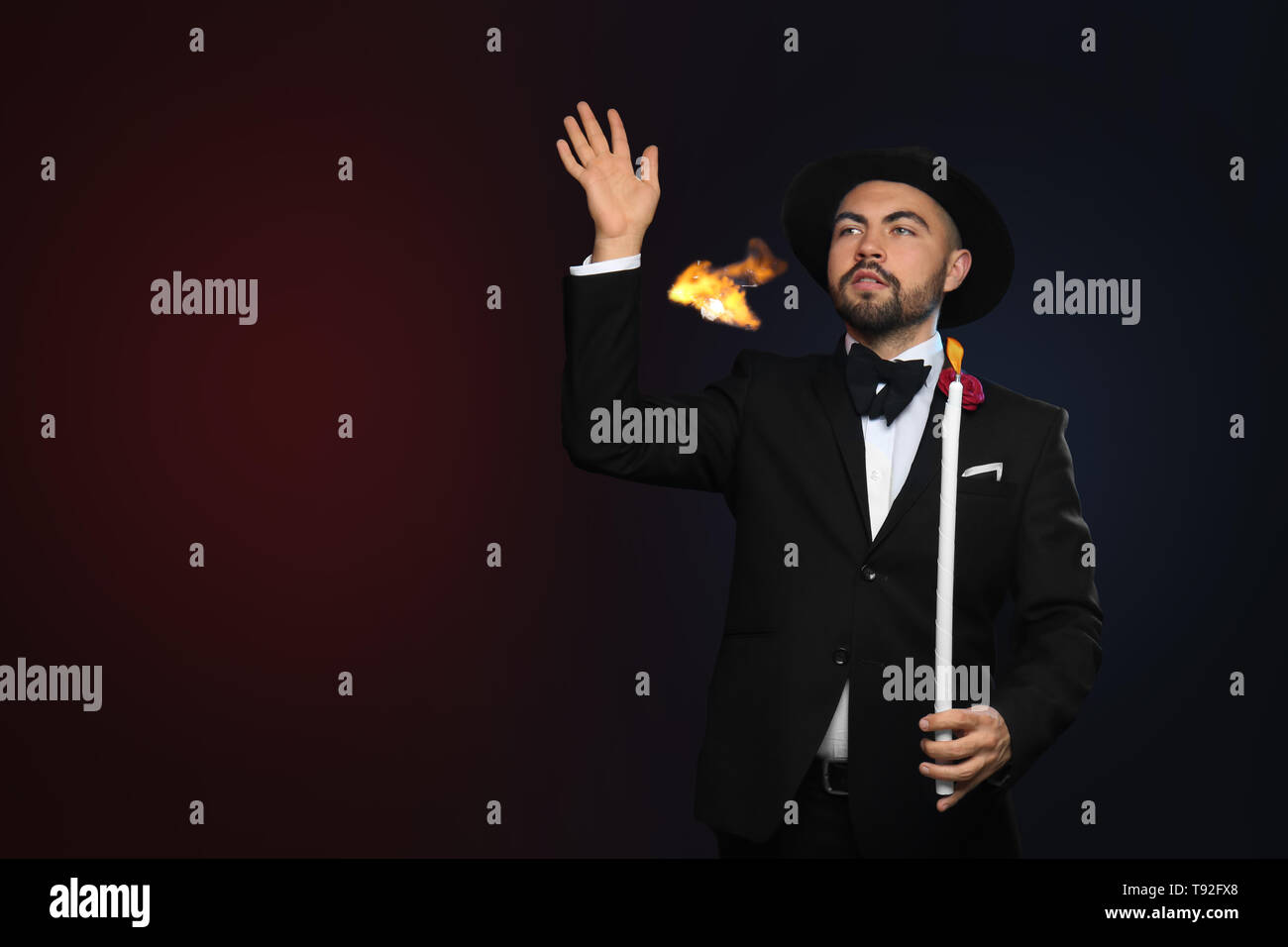 Male magician showing tricks on dark background Stock Photo - Alamy