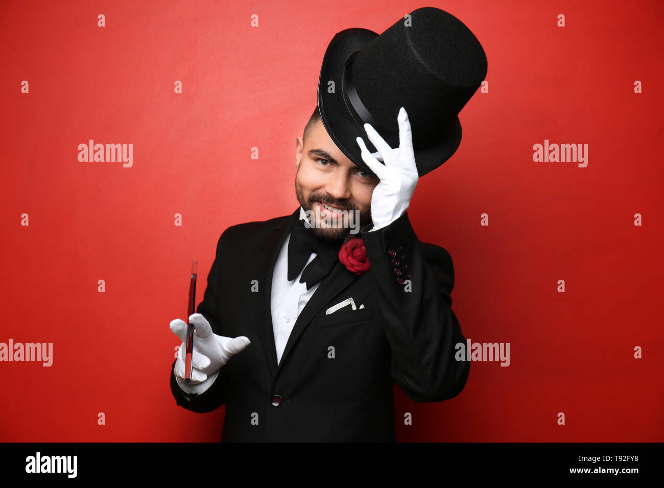 Male magician showing tricks on color background Stock Photo - Alamy