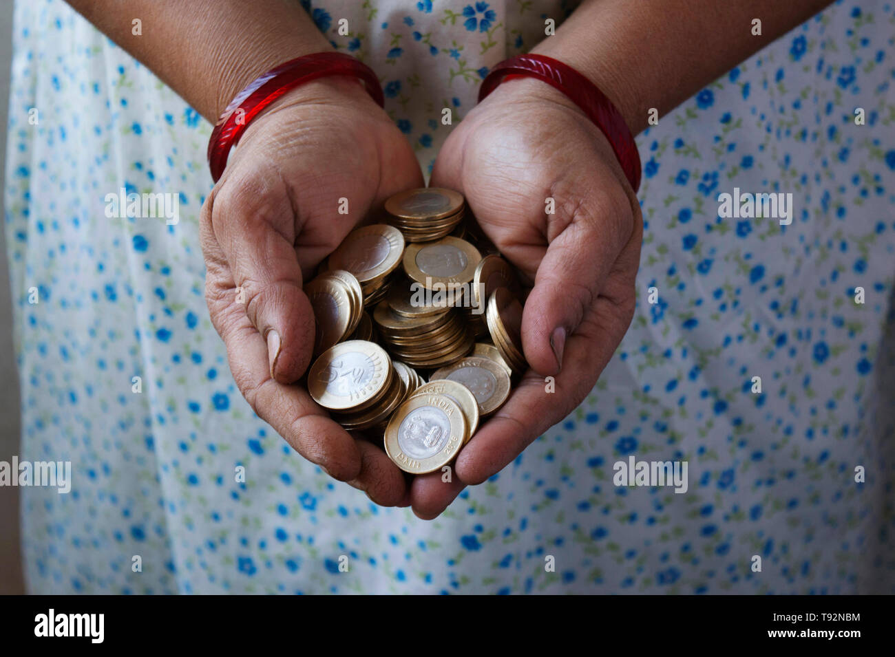 Hands holding 10 rupee coins. Stock Photo