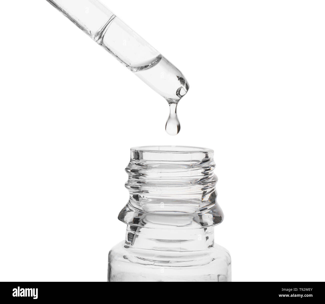 Liquid dripping from pipette into glass bottle on white background