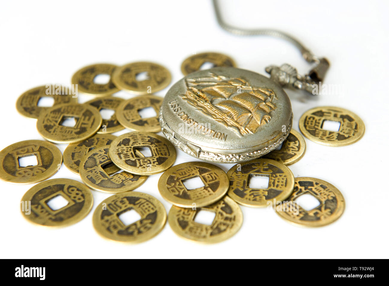 Pocket watch and ancient Chinese coins Stock Photo