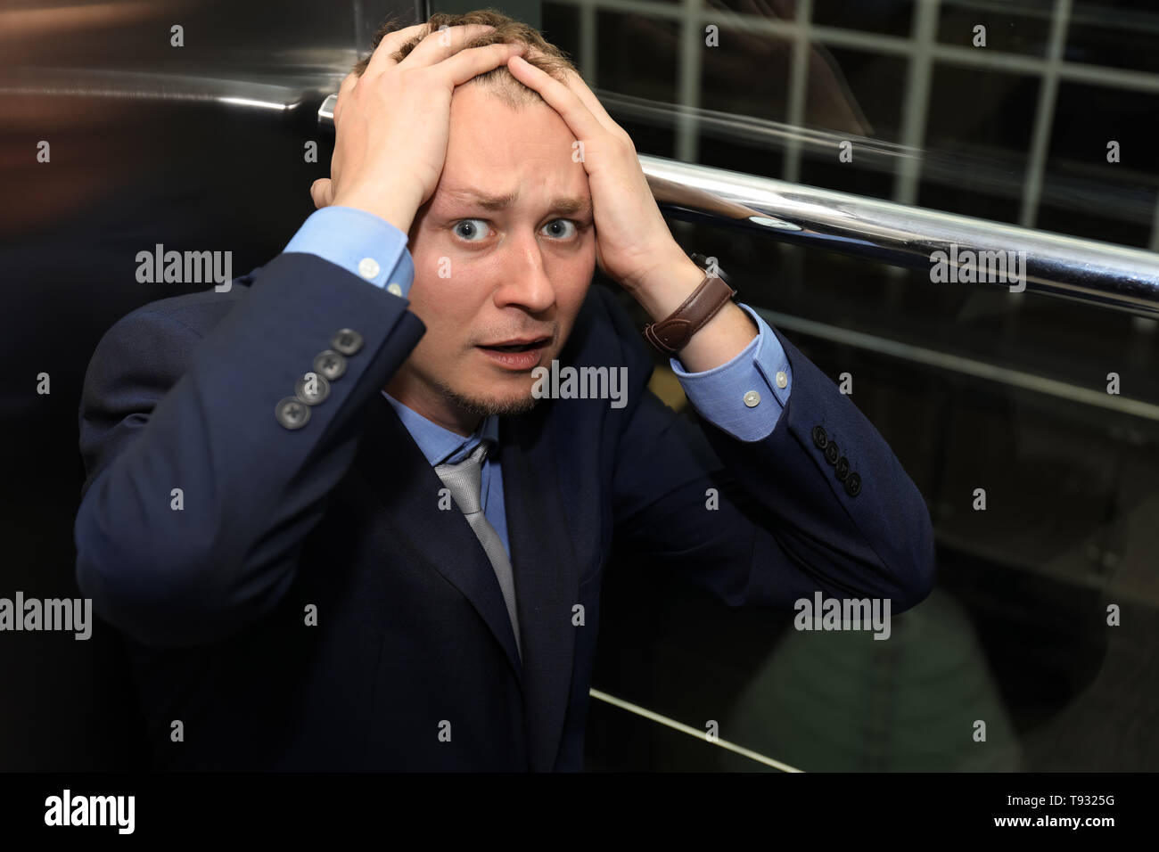 Businessman having panic attack in elevator Stock Photo