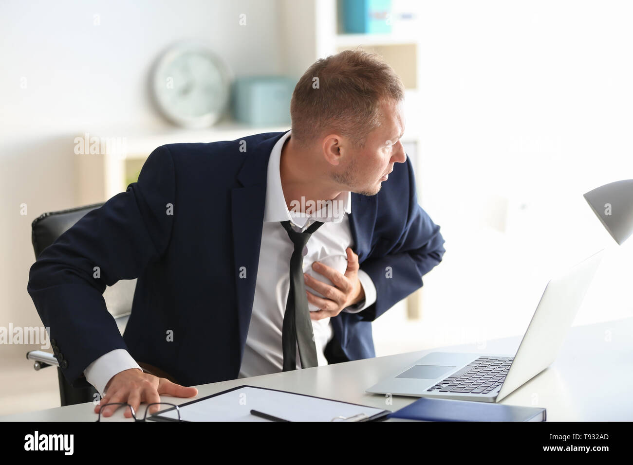 Man having panic attack at workplace in office Stock Photo