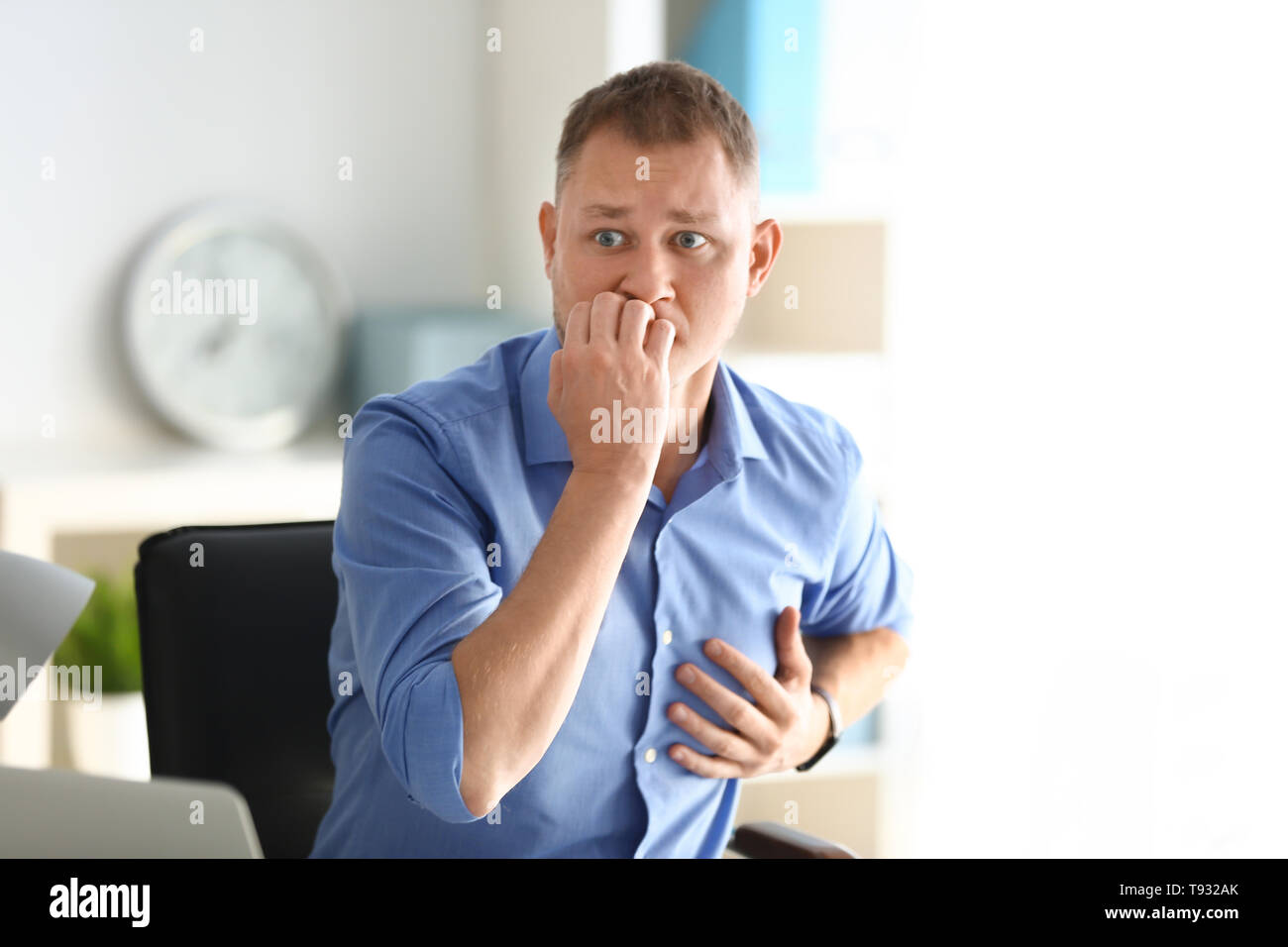Man having panic attack at workplace in office Stock Photo
