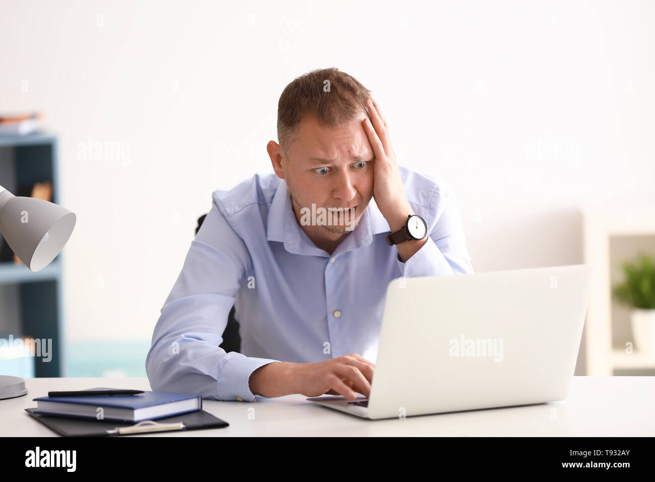 Man having panic attack at workplace in office Stock Photo